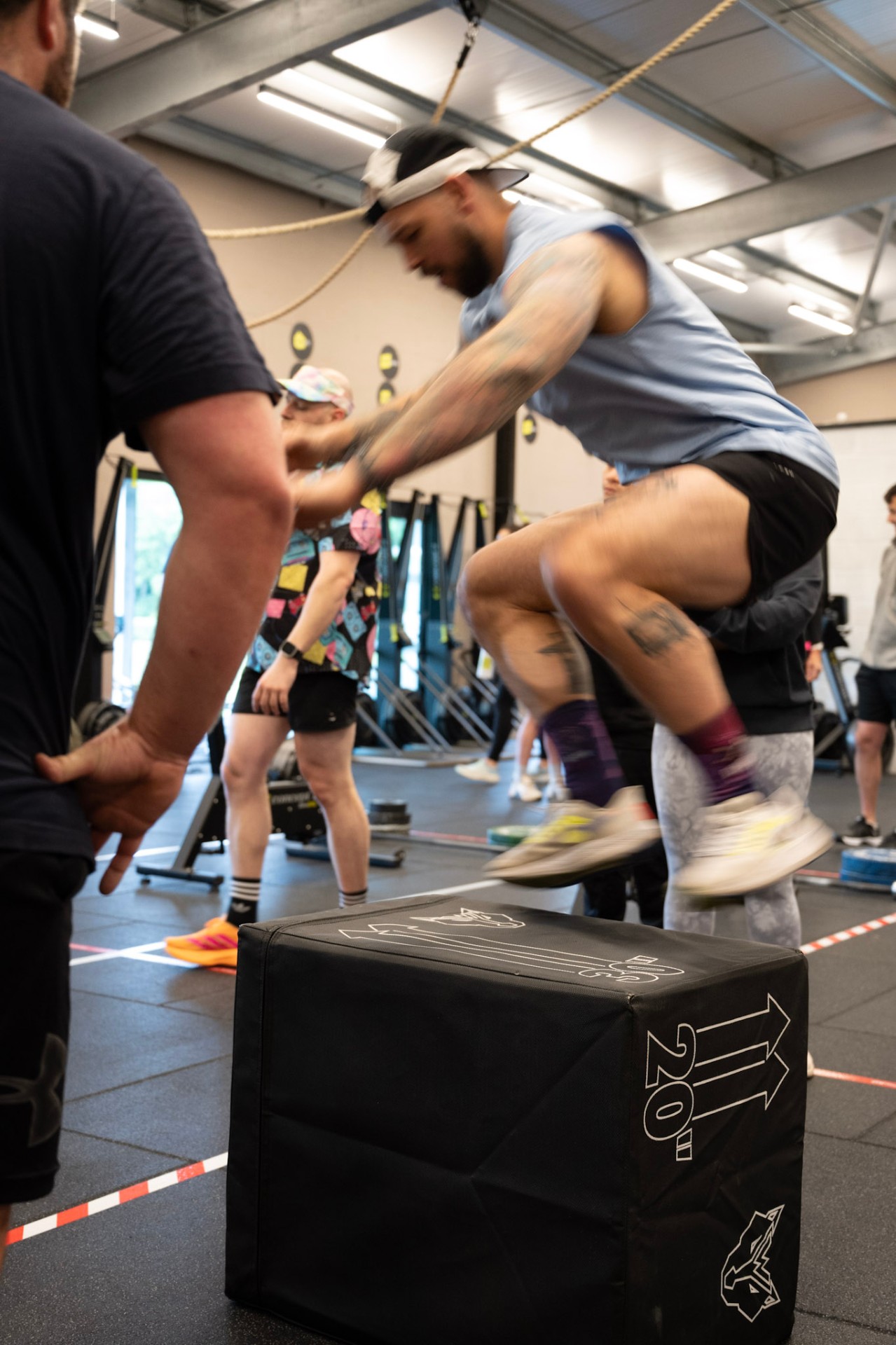Member jumping onto a plyo box mid-class