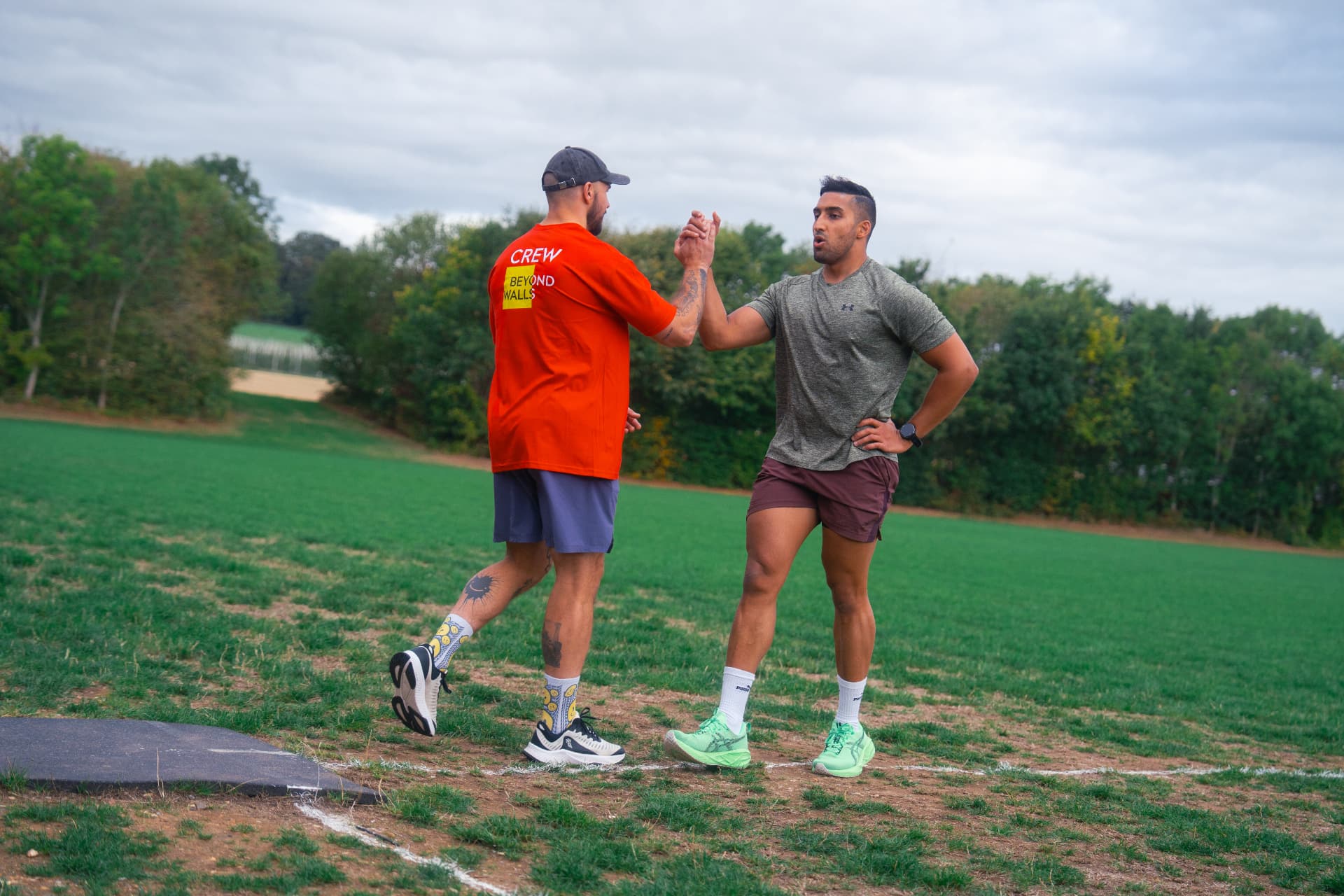 A Beyond Walls coach high-fiving a member during an outdoor session