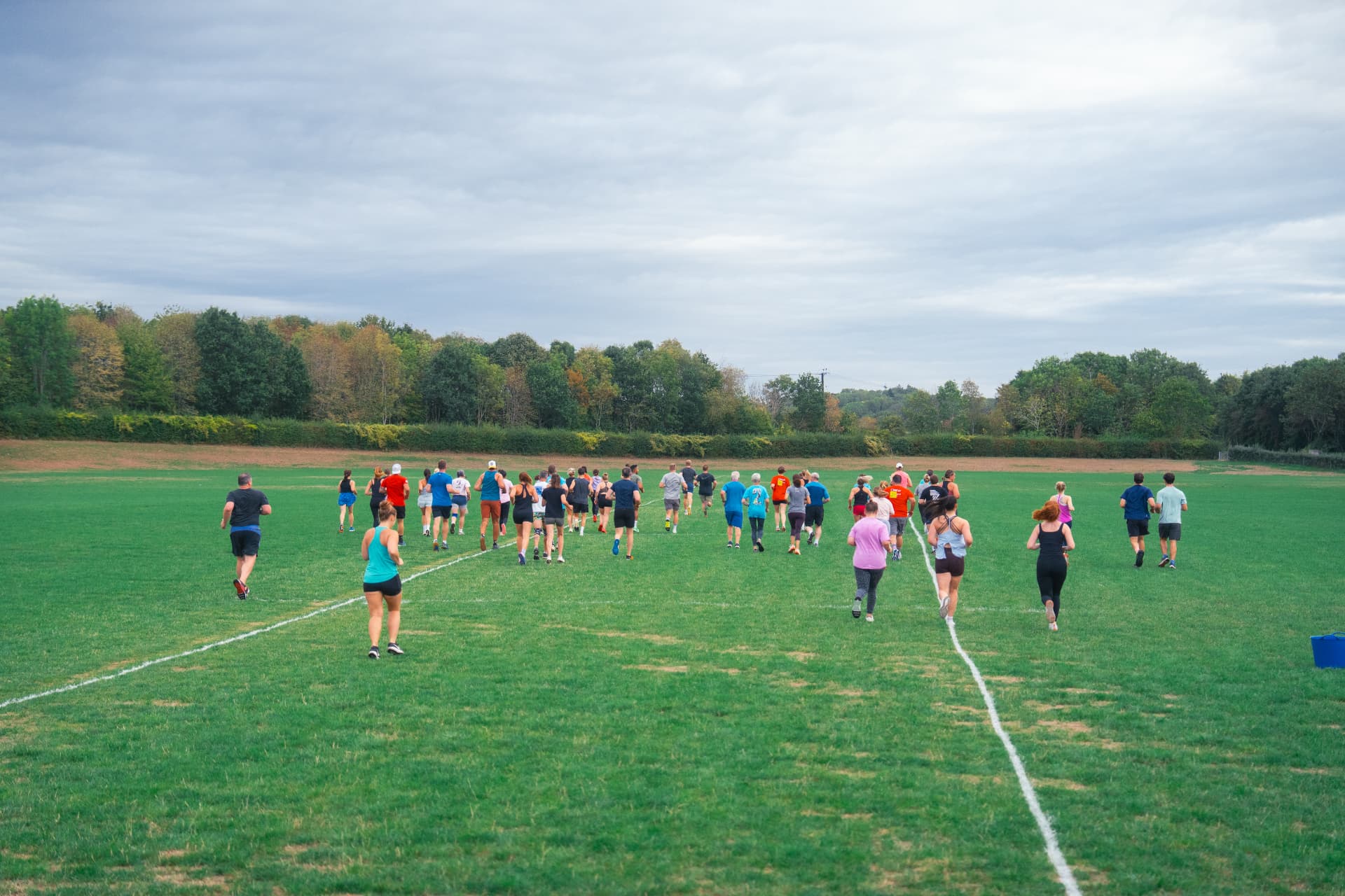 Beyond Walls members running together across the field at our gym in Cookham